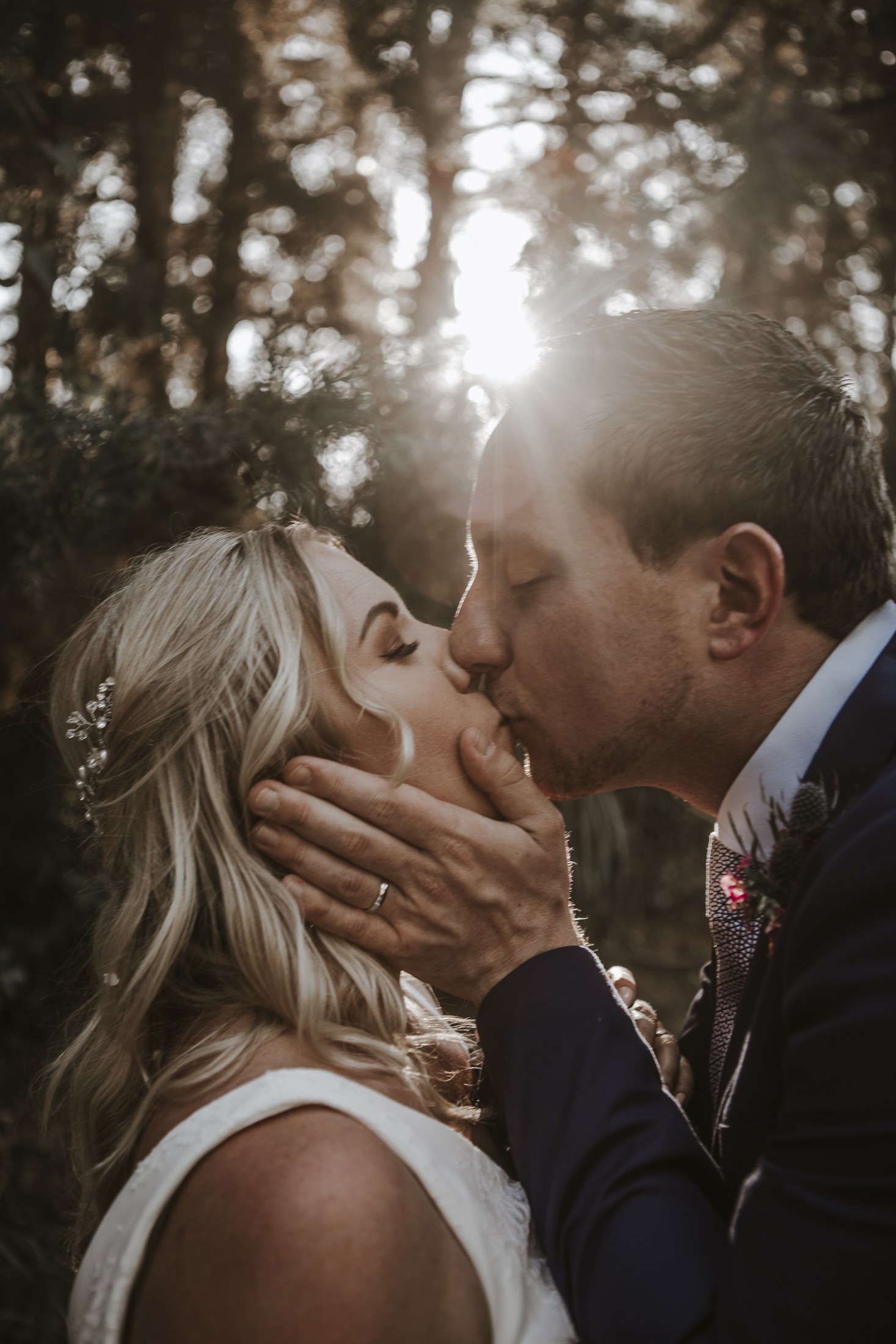Un beso a contraluz entre los árboles